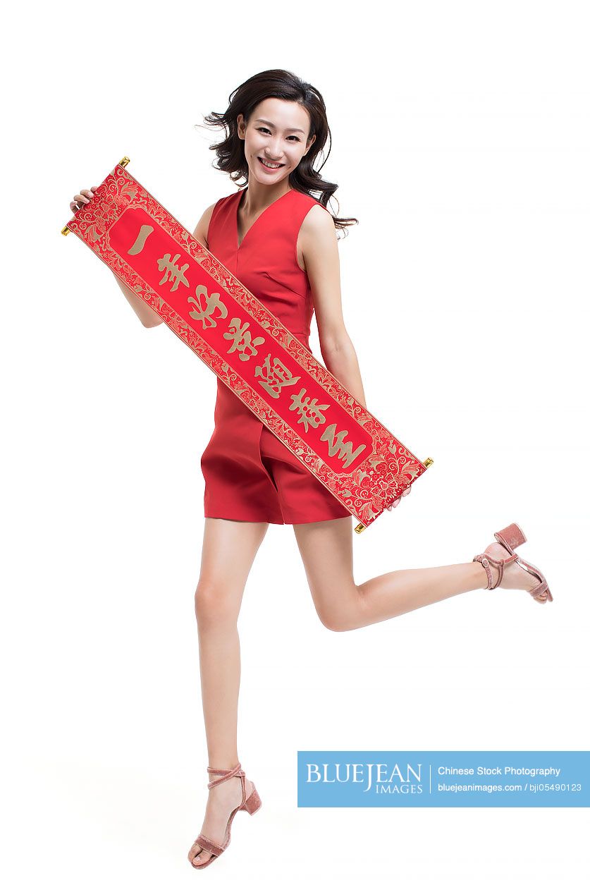 Cheerful young woman with couplet celebrating Chinese new year