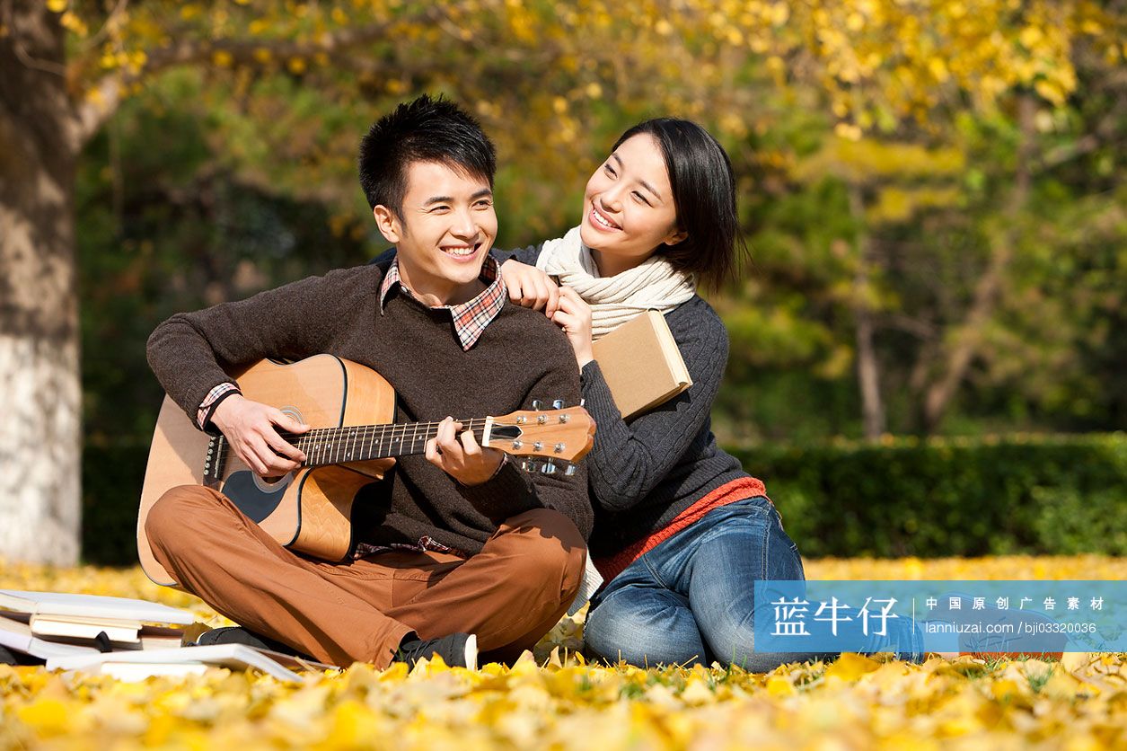 秋天校园大学生情侣与书本吉他