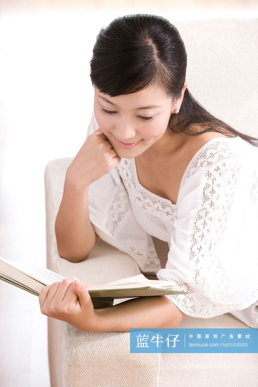 在沙发上看书的年轻女子