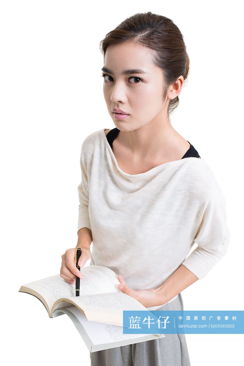 严肃的年轻女教师手拿课本授课