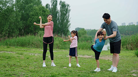 一家人在公园草坪上拉伸