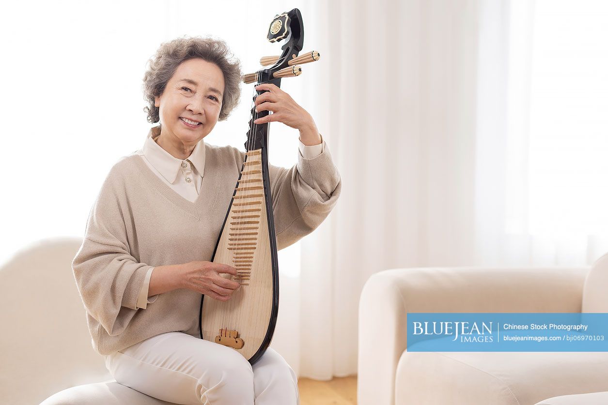 Senior Chinese woman plucking lute