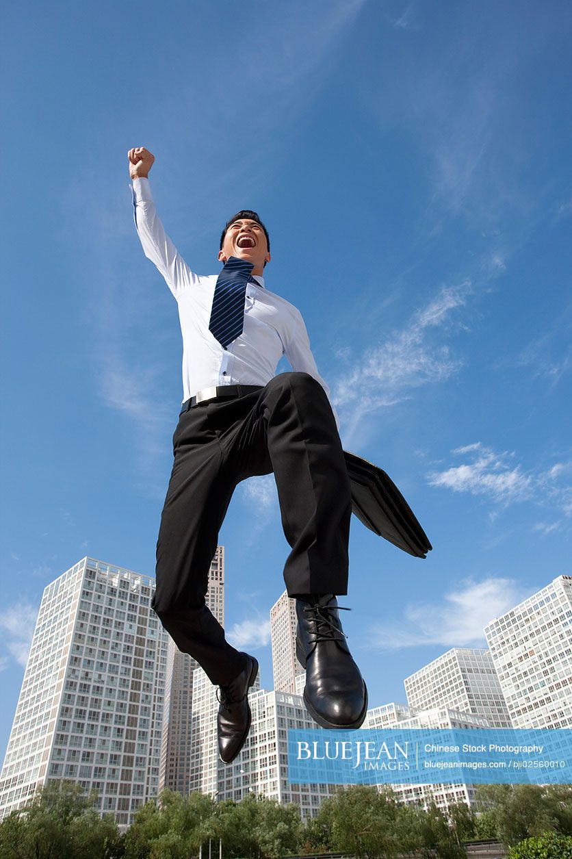 Excited Chinese businessman jumping