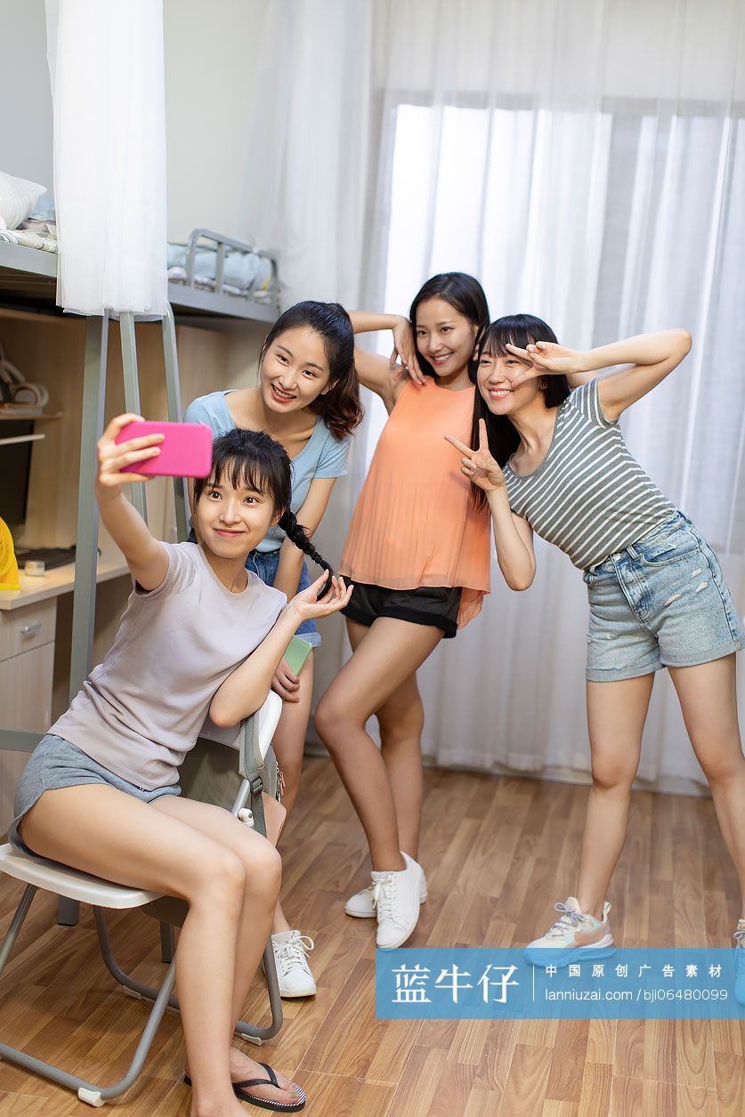 年轻大学生在宿舍用手机自拍