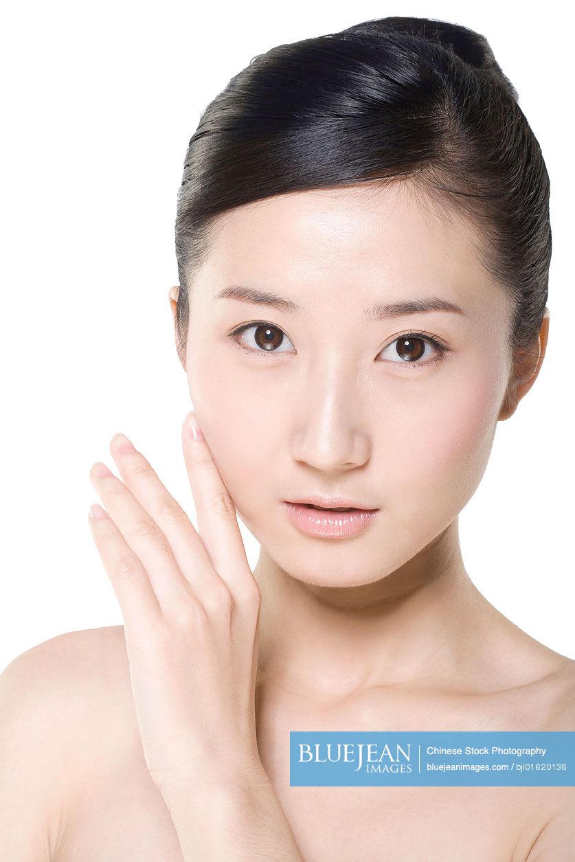Beauty shot of a young Chinese woman touching her face