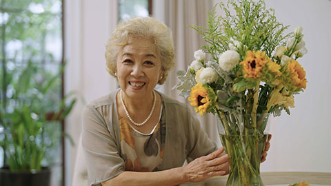 Happy senior Chinese woman arranging flowers at home,4K