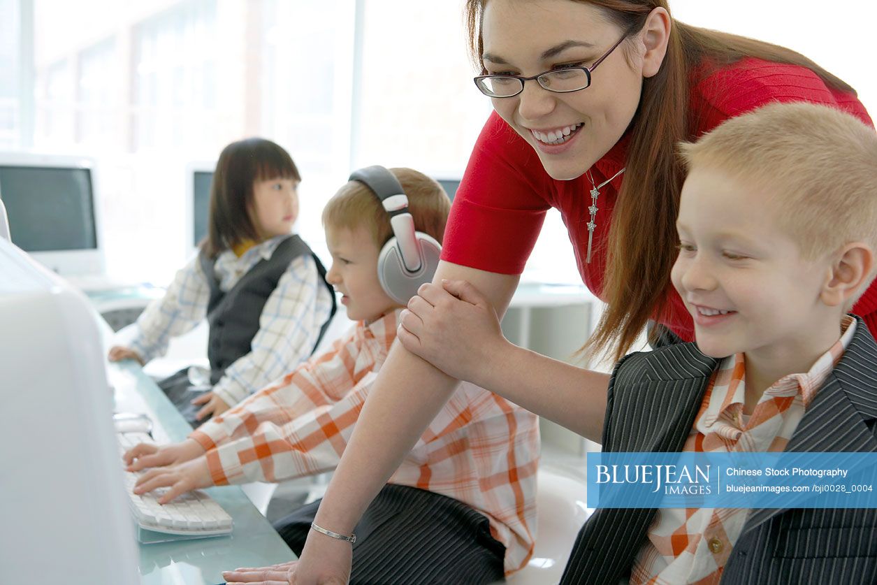Teacher and children in computer class-High-res stock photo for download