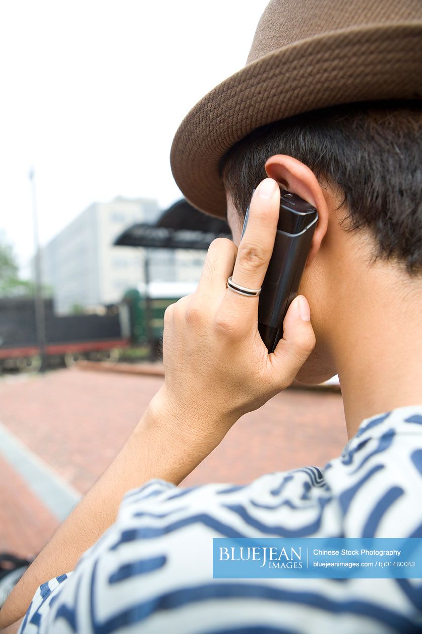 Young Chinese man using cell phone