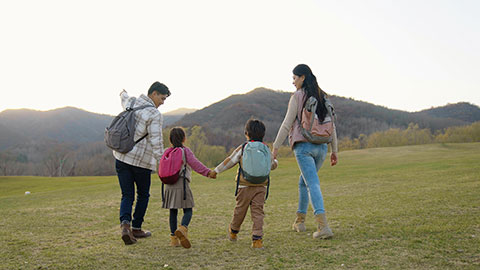 Happy young Chinese family hiking outdoors