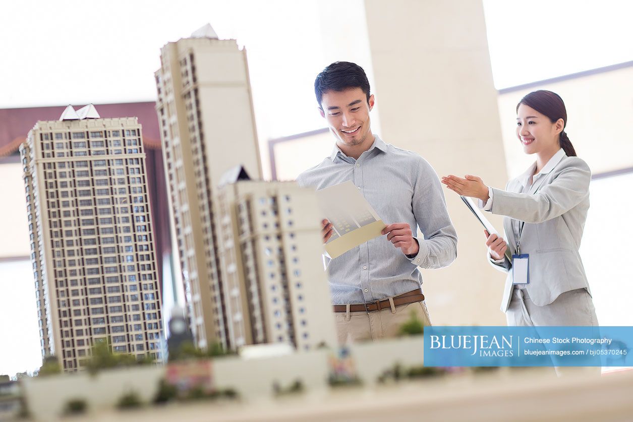 Chinese realtor showing architectural model to young man-High-res stock ...