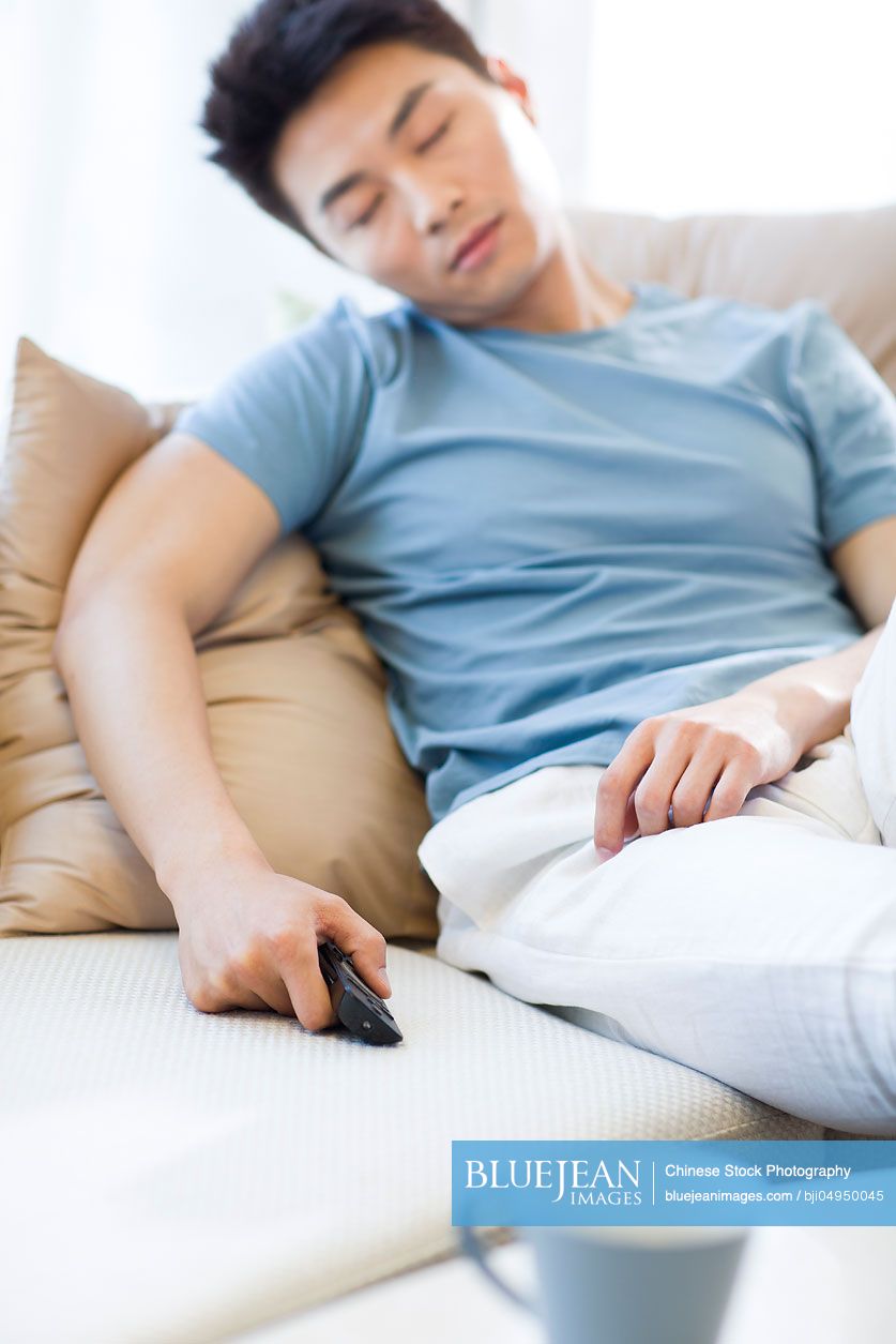 Young Chinese man sleeping on the sofa