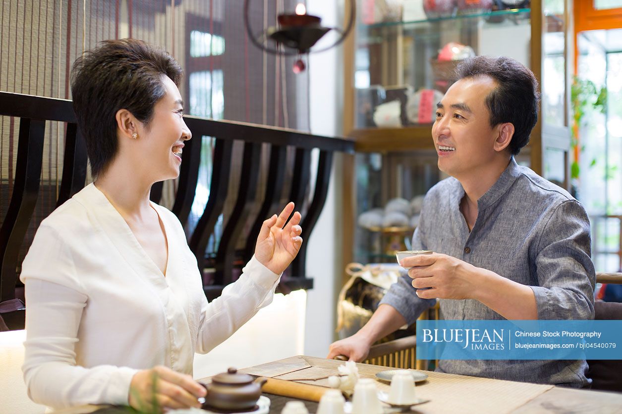 Chinese friends drinking tea and talking in tea room