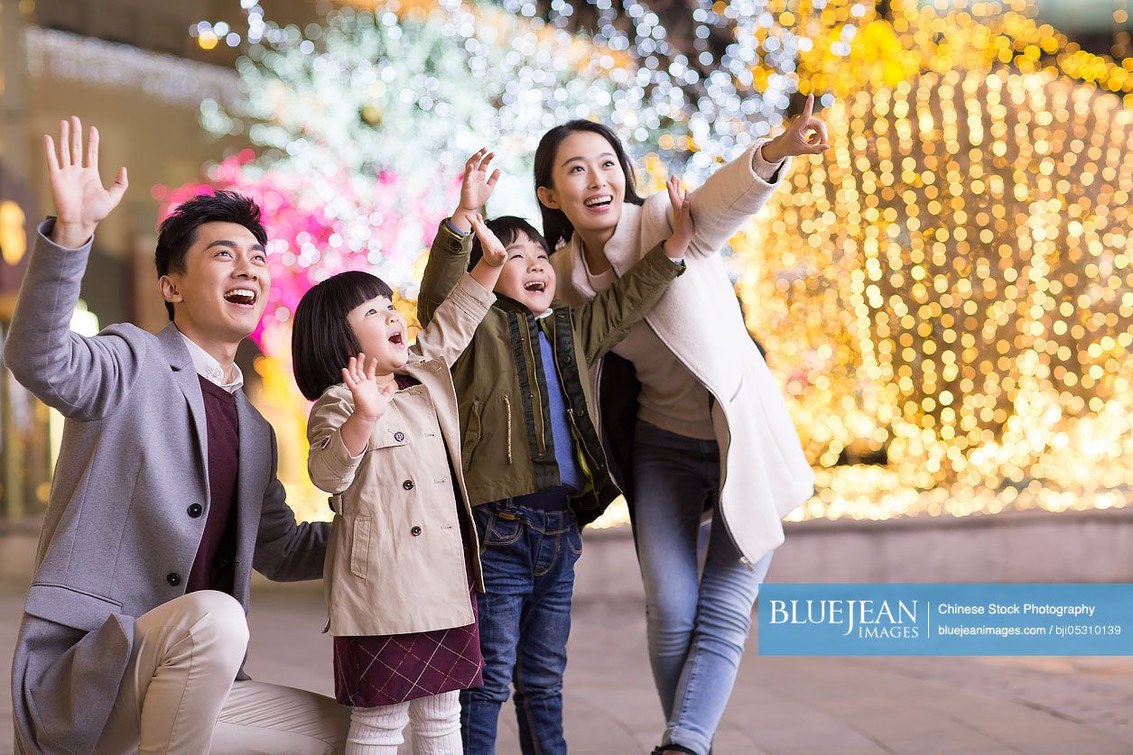 Cheerful young Chinese family waving