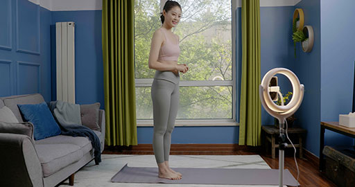 Female fitness influencer live-streaming a yoga session