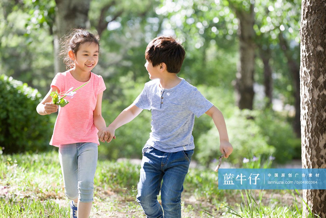 儿童手牵手在树林里奔跑
