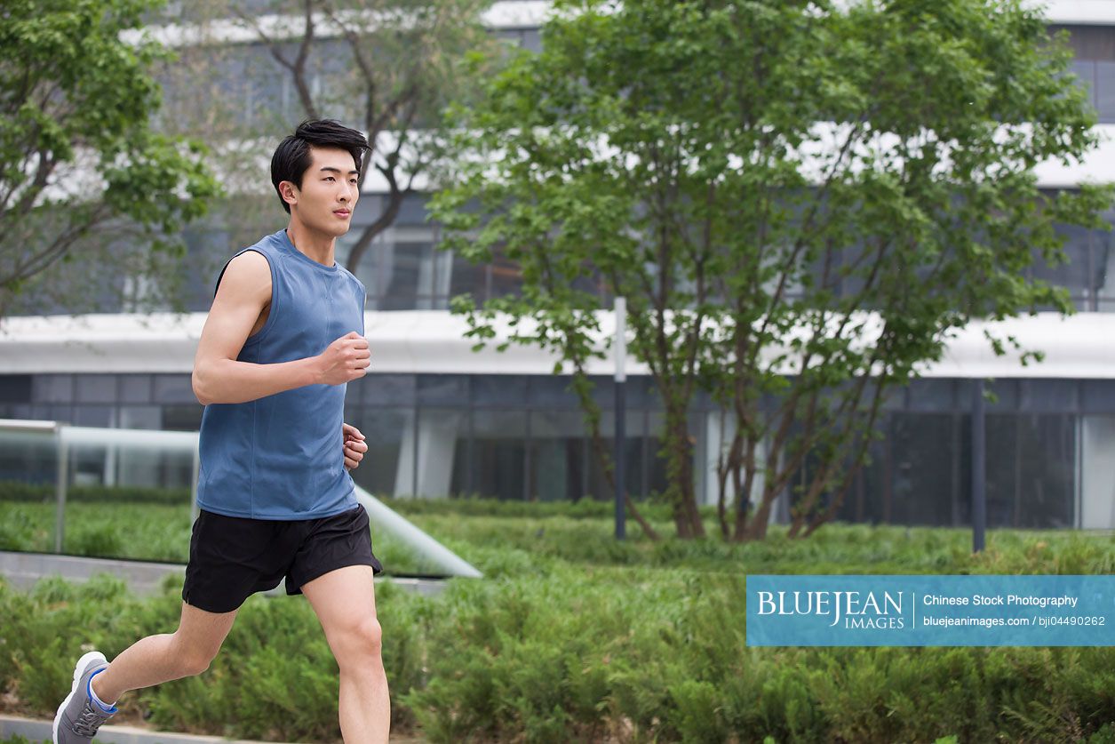 Young Chinese man running outside