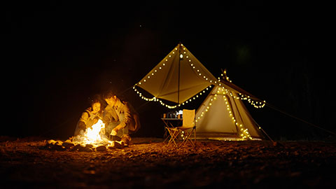 Happy young Chinese couple camping outdoors