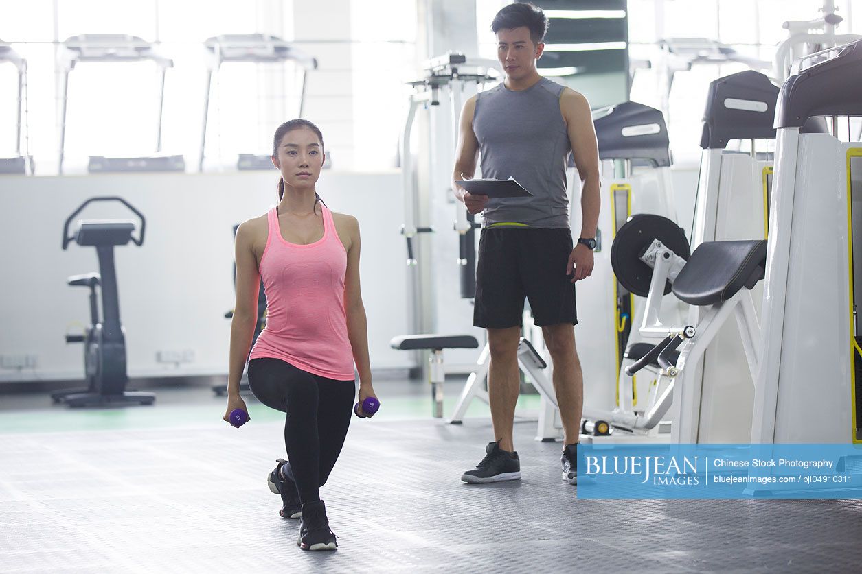 Young Chinese woman working with trainer at gym-High-res stock photo ...