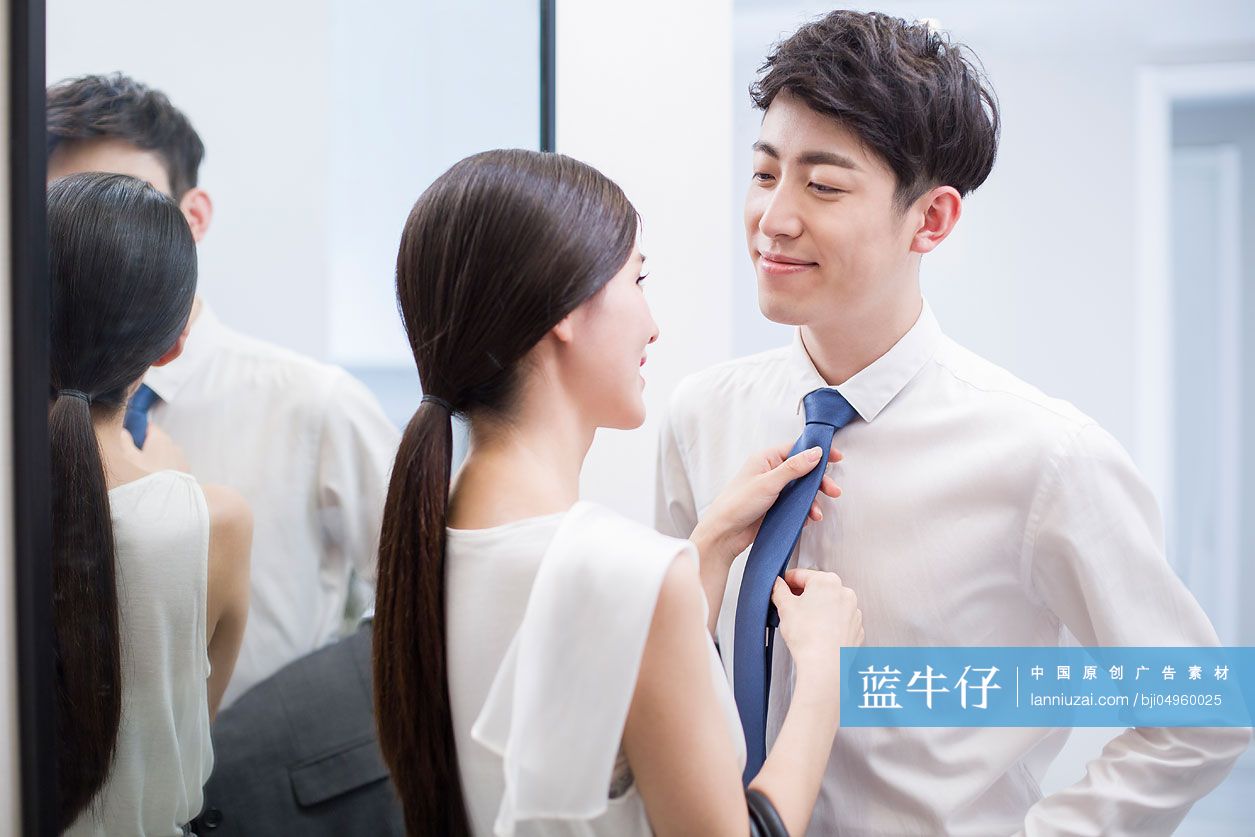 年轻女子帮丈夫调整领带