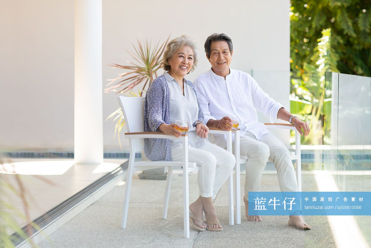 快乐的老年夫妇在阳台喝酒