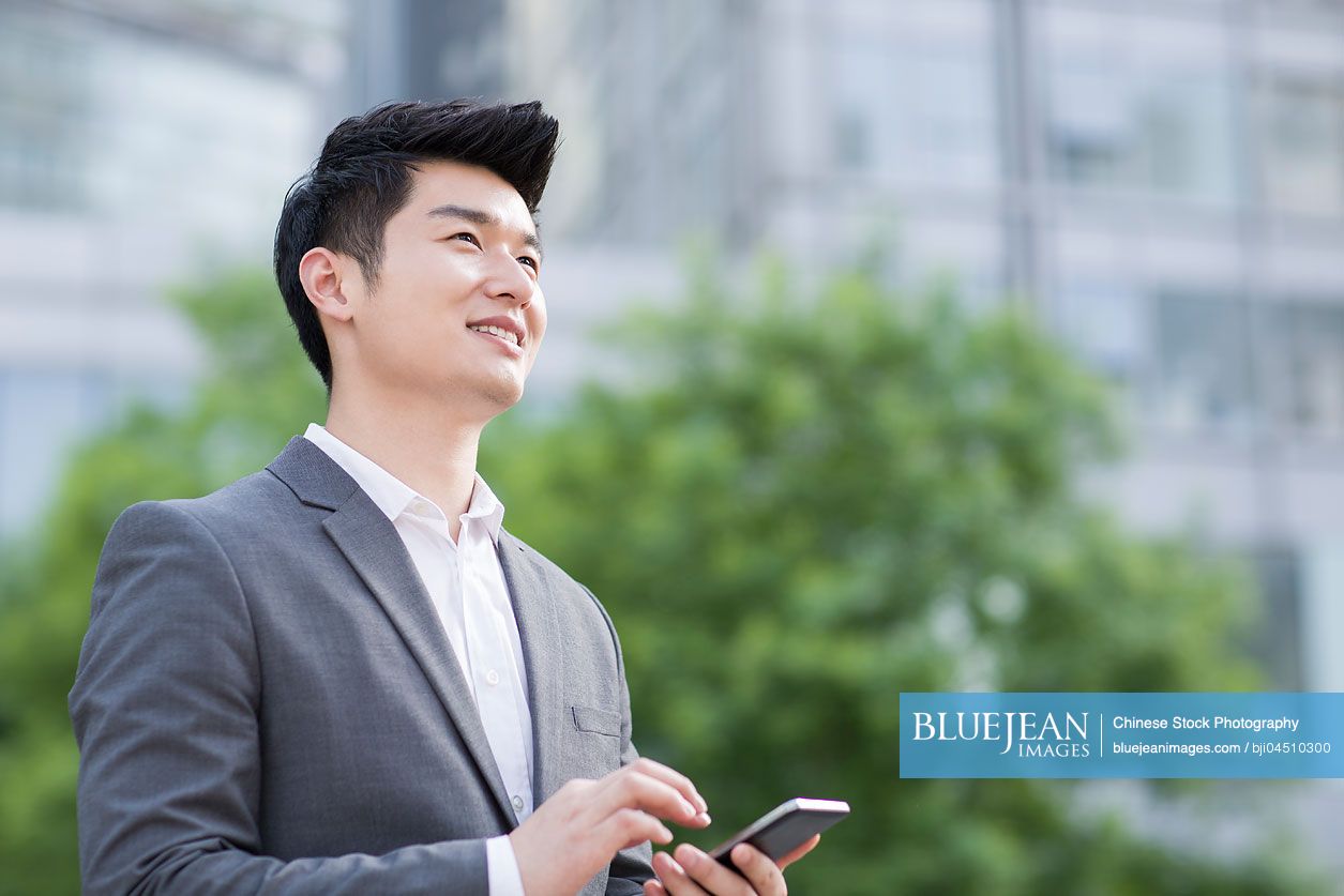 Young Chinese businessman with smart phone
