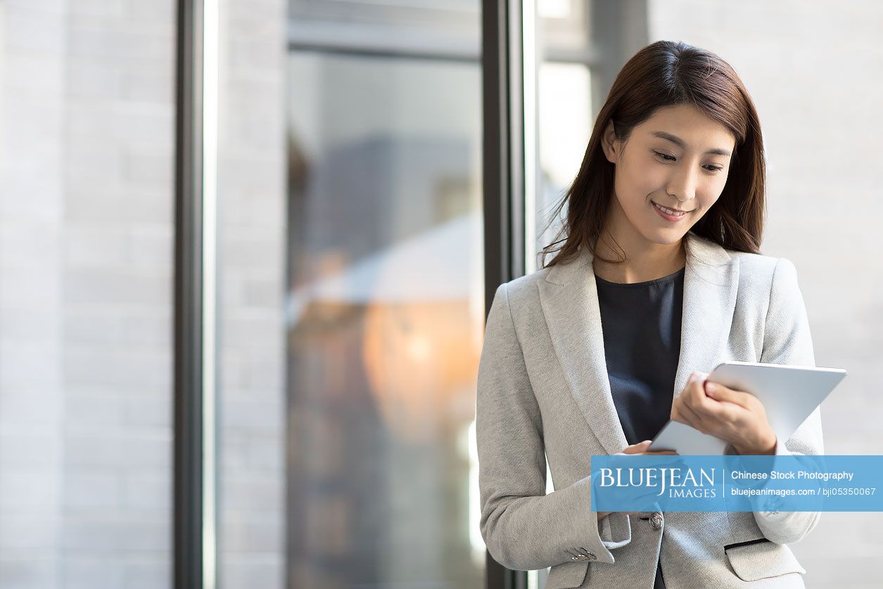 Young Chinese businesswoman holding a digital tablet