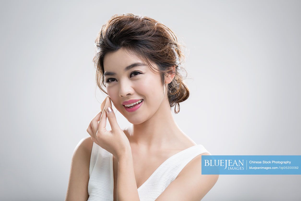 Young Chinese woman applying facial powder