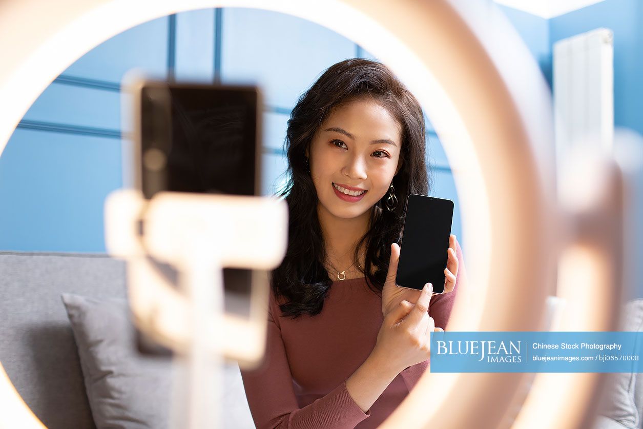 Young Chinese woman doing live webcast at home