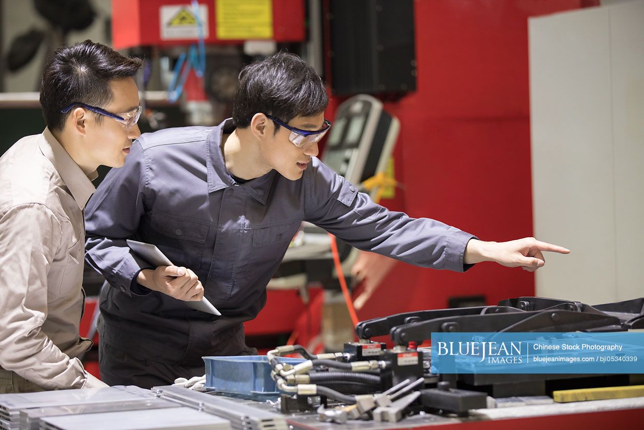 Confident Chinese engineers working in the factory