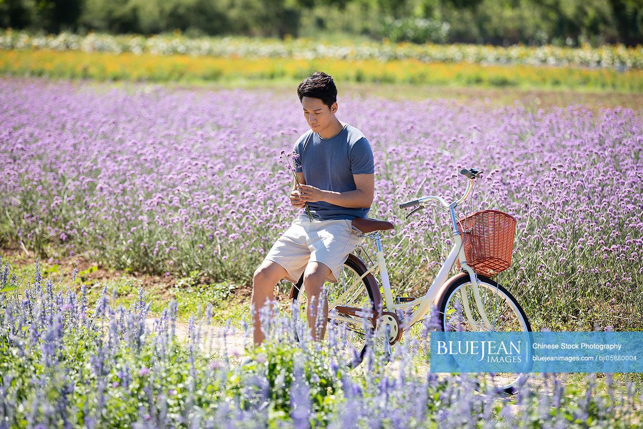 Happy young Chinese man in flower field