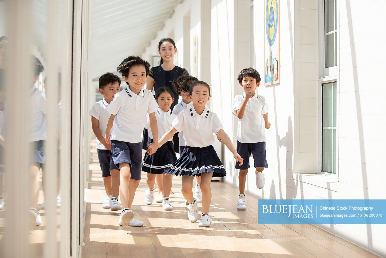 Chinese teacher and children in school hallway