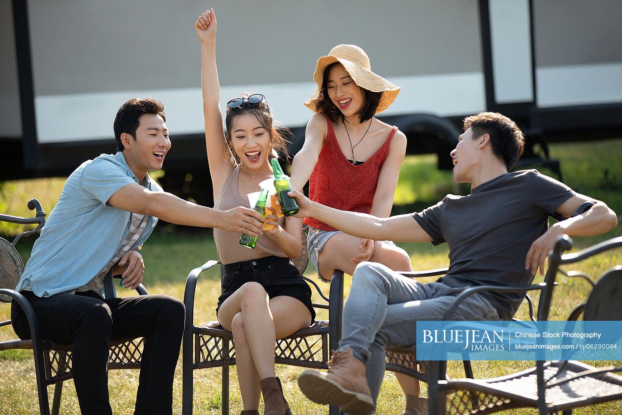 Happy young Chinese friends having a picnic outdoors