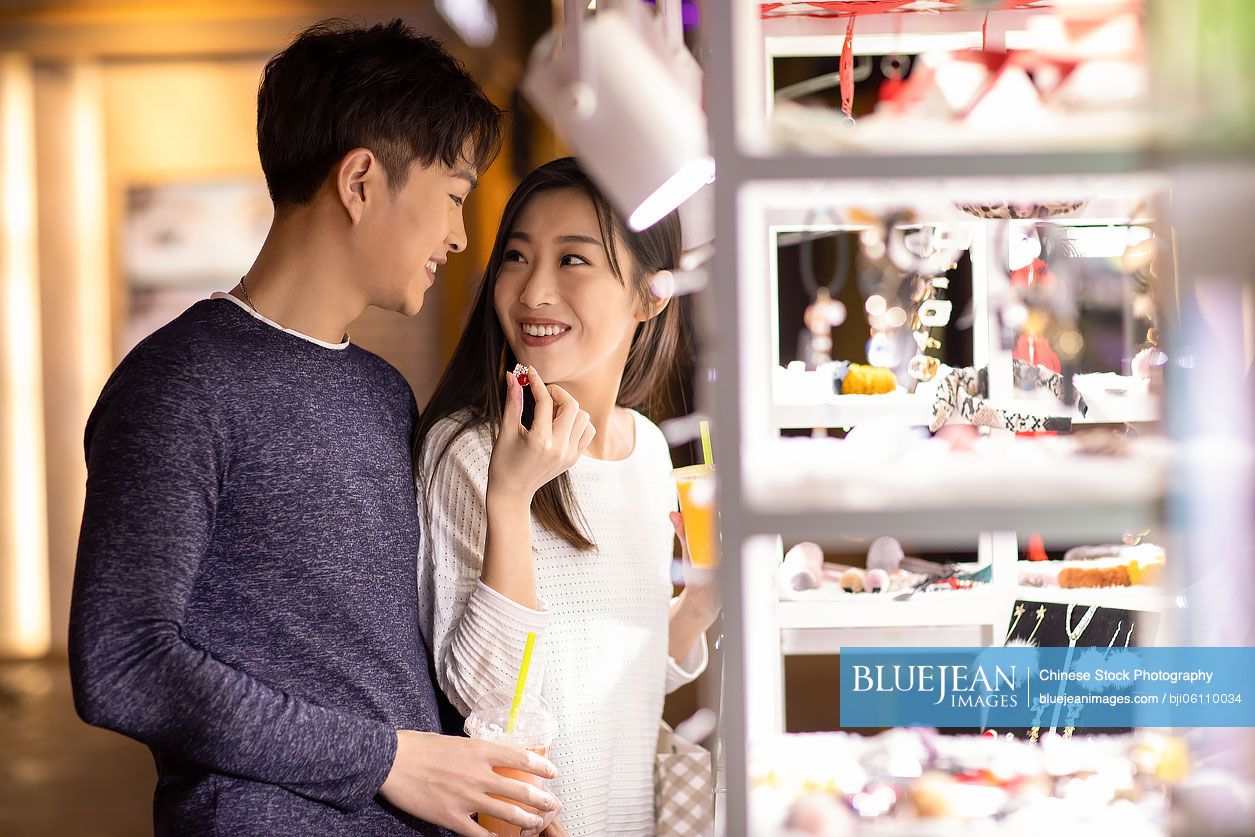 Happy young Chinese couple dating in shopping mall
