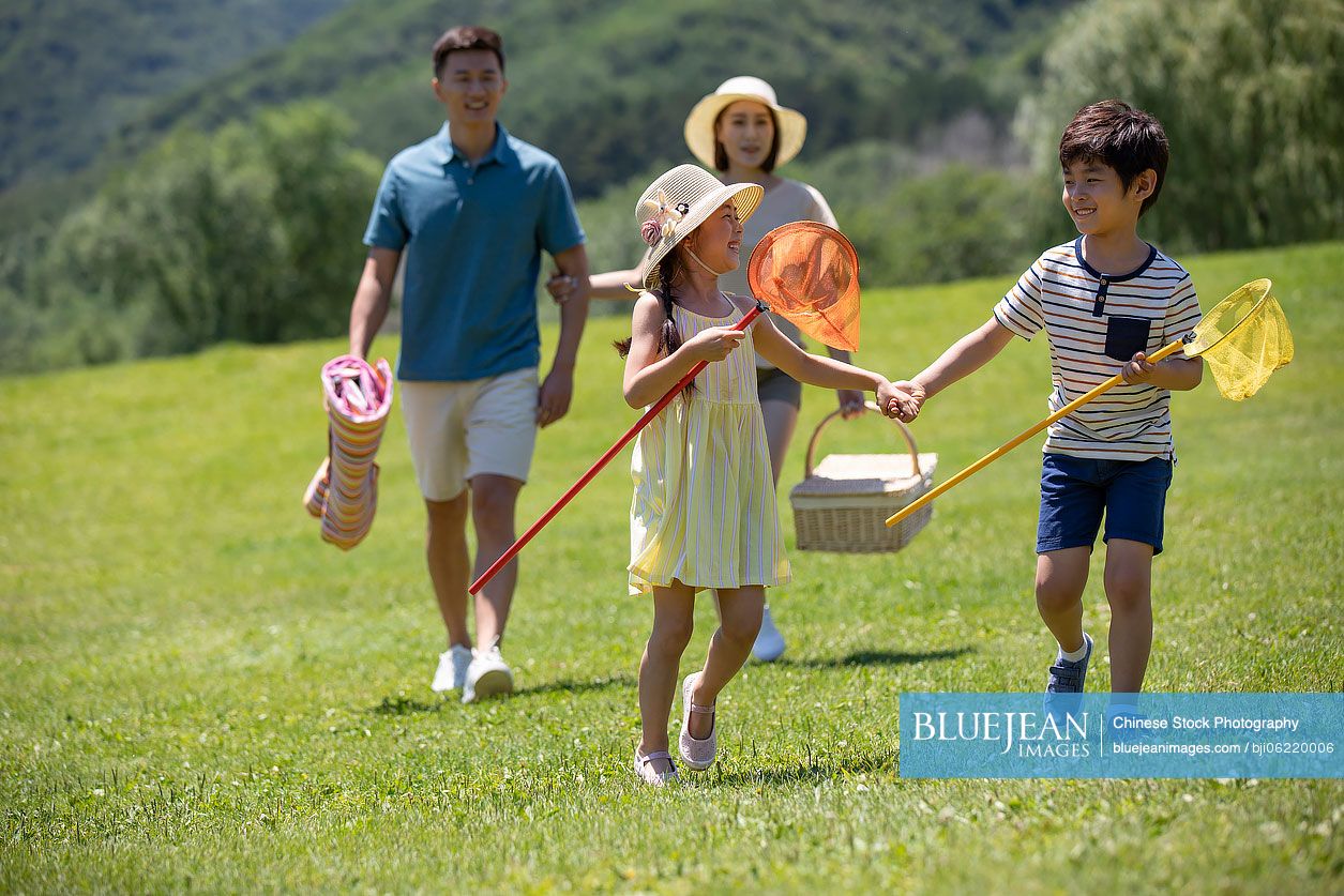 Happy young Chinese family going for picnic