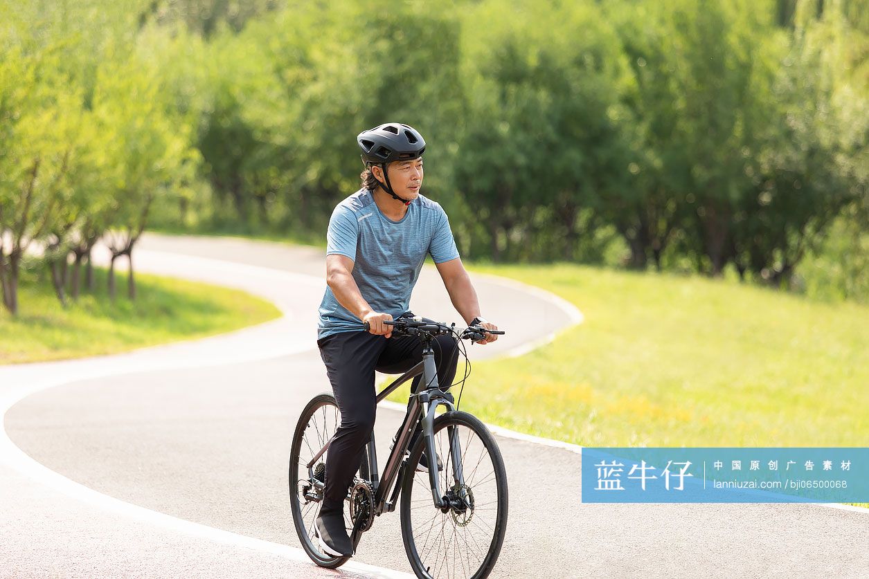 开心的中老年男子在公园骑自行车