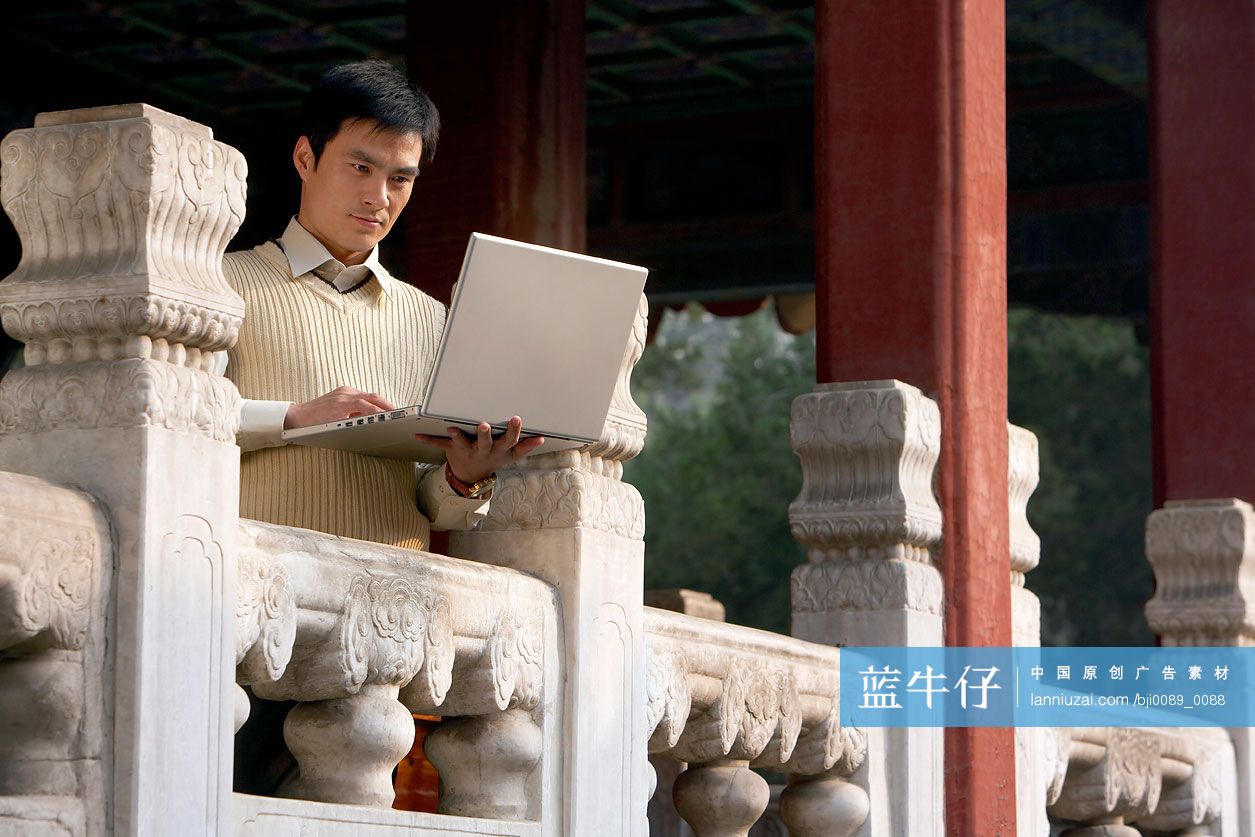 故宫里的商务男士使用笔记本电脑