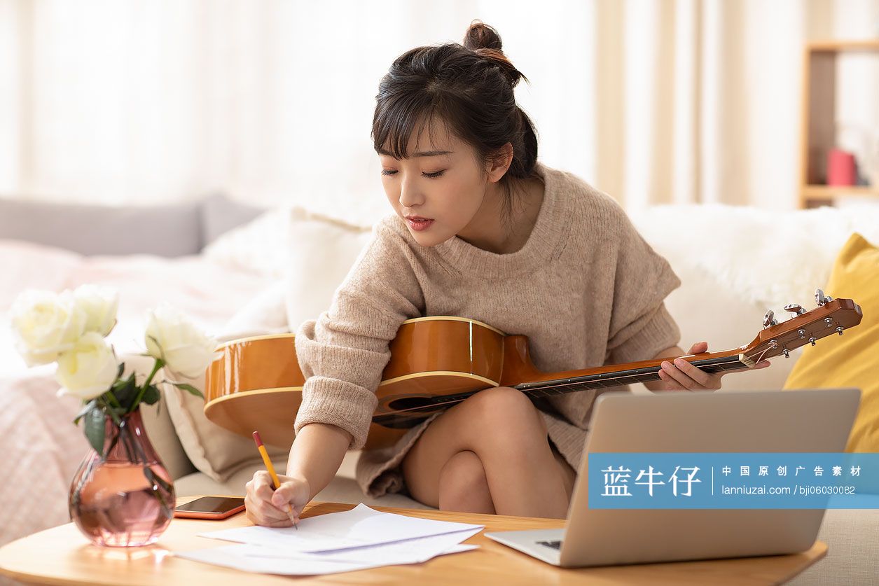 年轻女士在家弹吉他