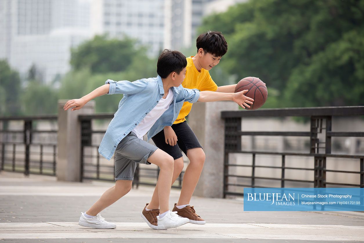 Chinese boys playing basketball outdoors