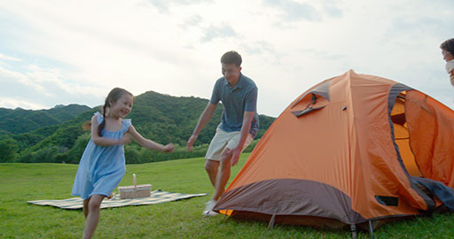Happy young Chinese family camping outdoors,4K