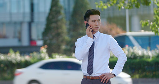 Young Chinese businessman using smartphone on street,4K
