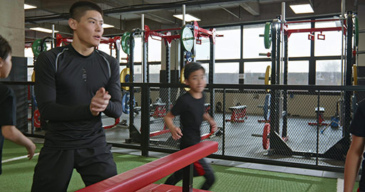 Active Chinese children having exercise class with their coach in gym,4K