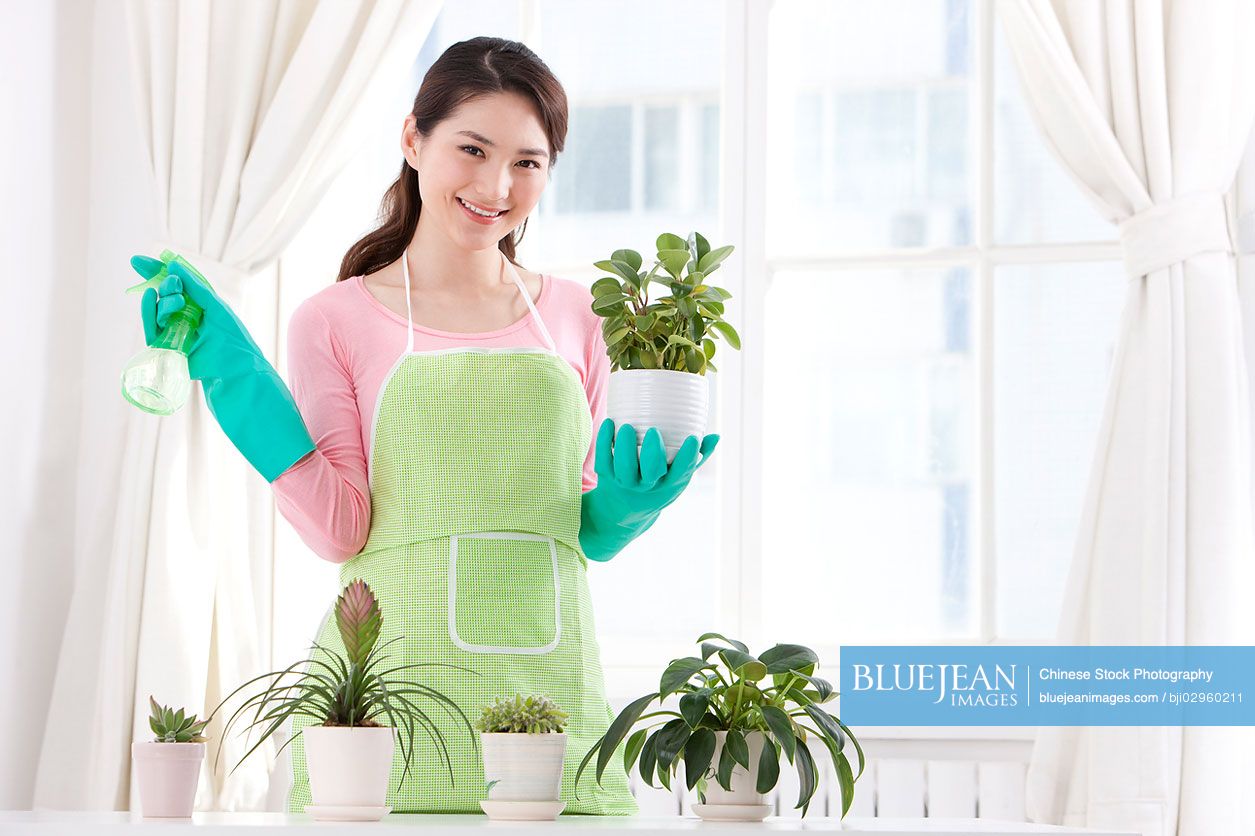 Young Chinese woman watering plant