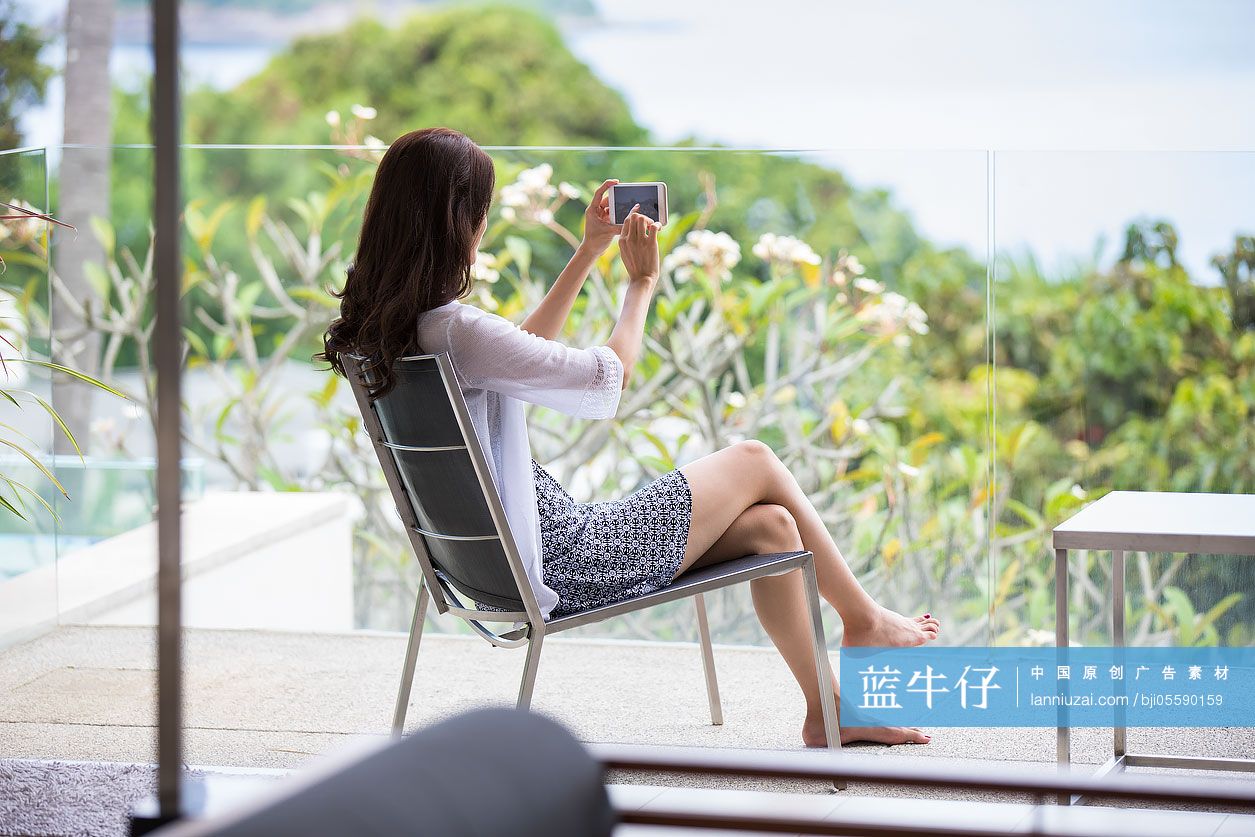 快乐的年轻女子在阳台上拍照