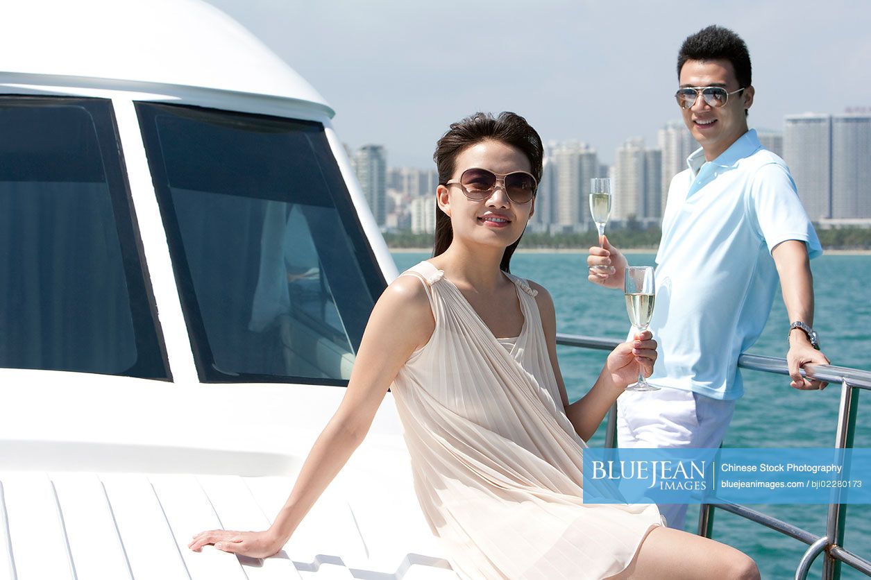 Chinese couple relaxing on a yacht