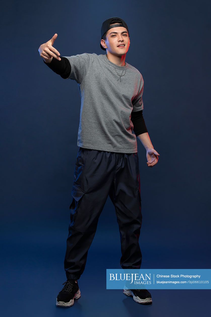 Studio shot of fashionable young Chinese man dancing