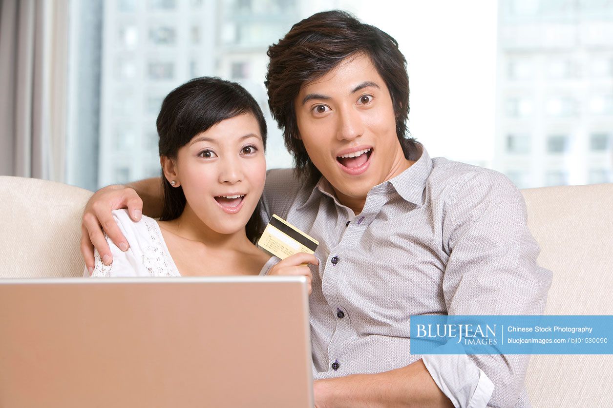 Chinese couple cuddling on a sofa