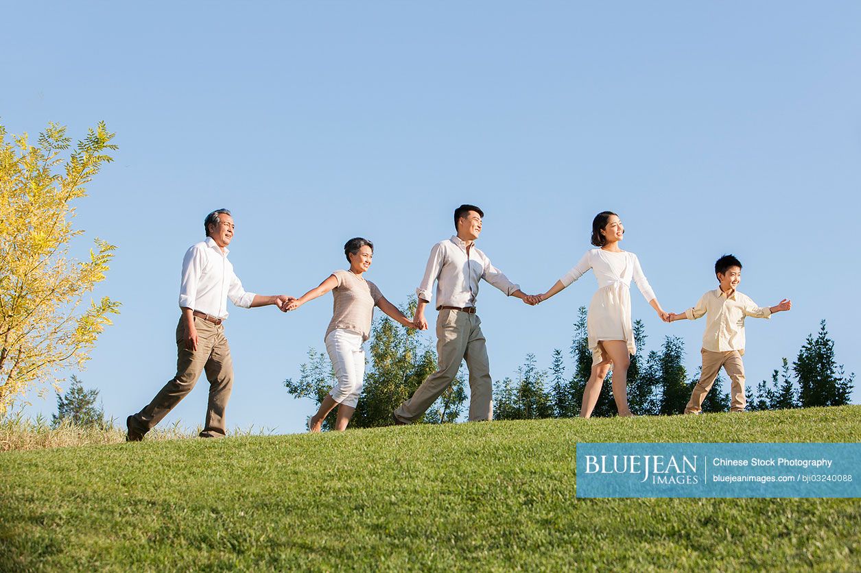 Chinese big family holding hands one after another in a park