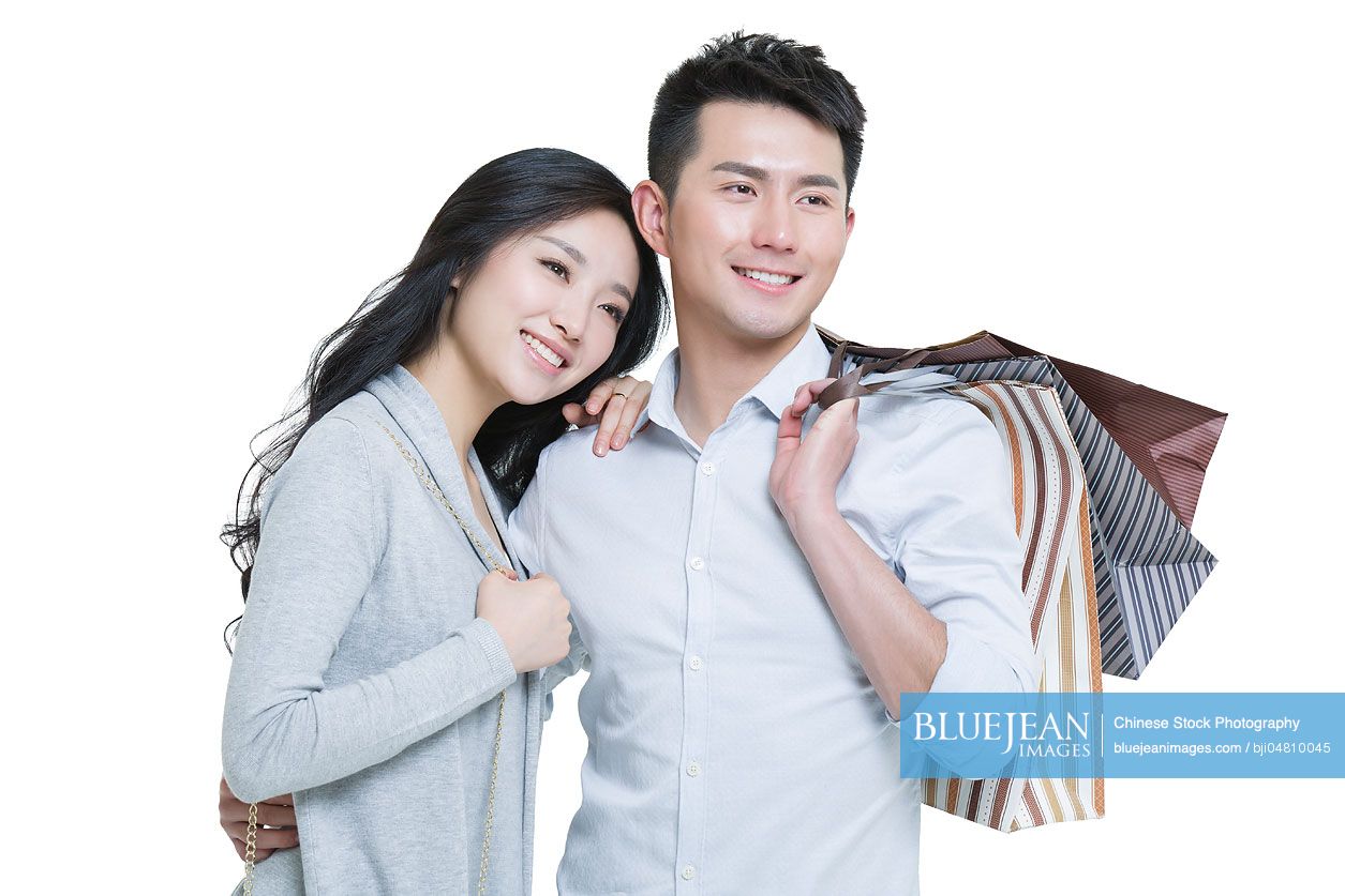 Happy young Chinese couple with shopping bags