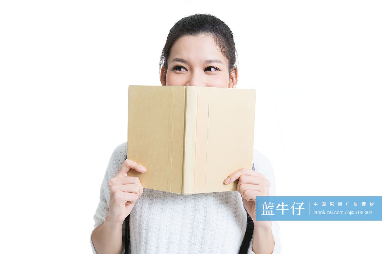开心的女大学生拿书捂着嘴