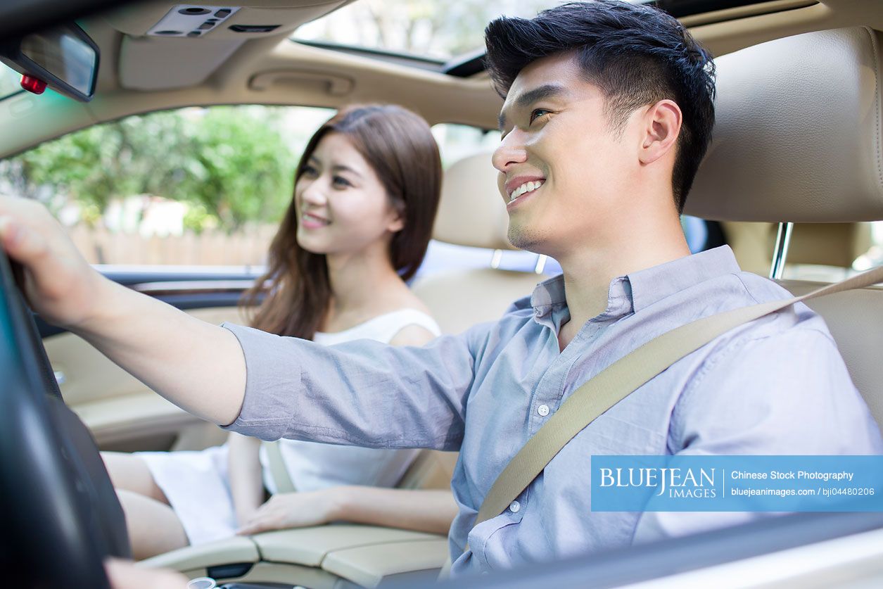 Happy young Chinese couple in a car